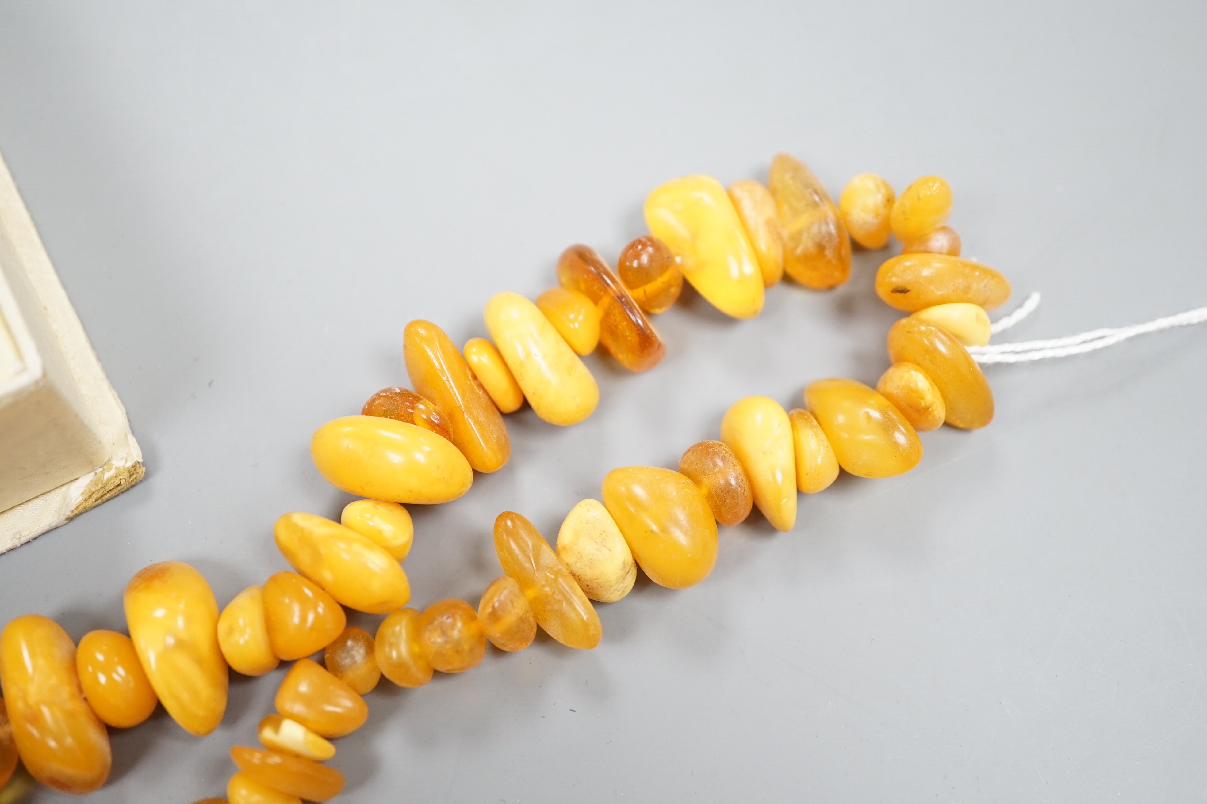 An amber bead necklace, gross 72 grams and a costume bracelet and earclips.